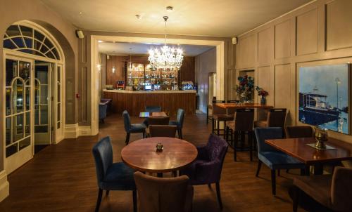 a restaurant with tables and chairs and a bar at The View Hotel Folkestone, a member of Radisson Individuals in Folkestone