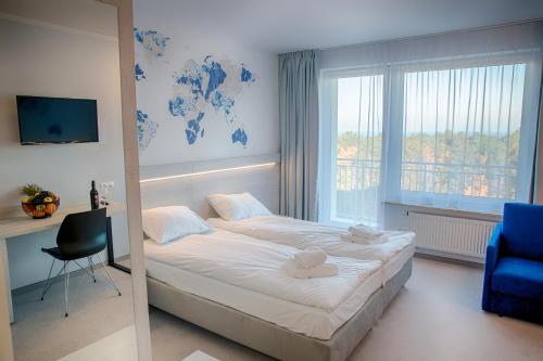 a bedroom with a large bed and a blue chair at Mielno Holiday Apartments in Mielno