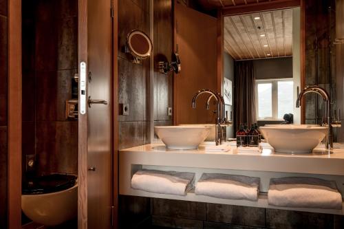 a bathroom with two sinks and two mirrors at Copperhill Mountain Lodge in Åre