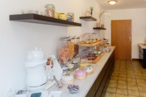 eine Küche mit einer Theke mit vielen Gegenständen darauf in der Unterkunft Hotel & Apartment Am Theaterplatz in Bremerhaven