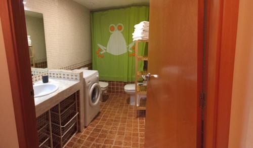 La salle de bains est pourvue de toilettes et d'un rideau de douche vert. dans l'établissement Apartamento frente Pistas de Esquí La Molina, à La Molina