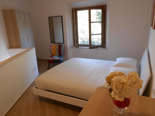 1 dormitorio con 1 cama y un jarrón de flores sobre una mesa en CIVICO 47, en Pisa