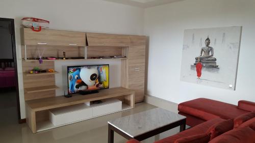 Samui Grand Rock في شاطئ لاماي: غرفة معيشة مع أريكة وتلفزيون