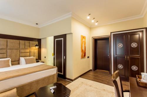 a hotel room with a bed and a desk at Ambassador in Almaty