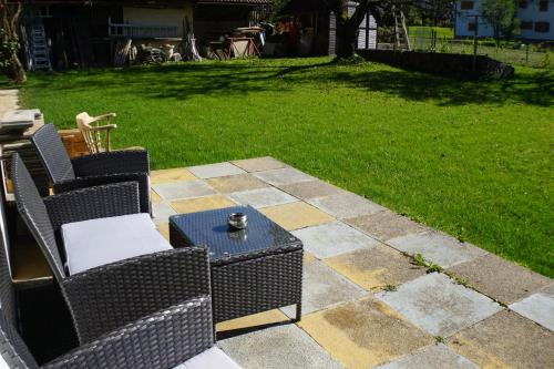 a patio with two chairs and a table in a yard at Parkweg Lodge in Faak am See