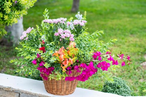 a basket filled with flowers sitting on a table at Pyrgaki Hotel in Parikia