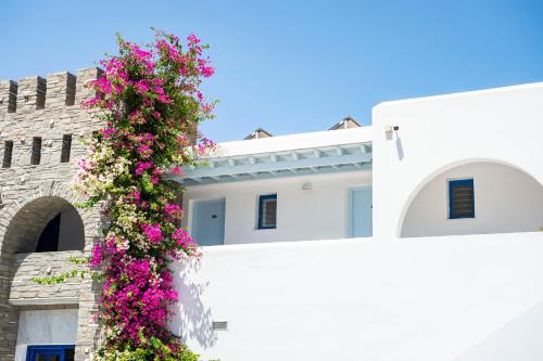 a white building with pink flowers on it at Pyrgaki Hotel in Parikia