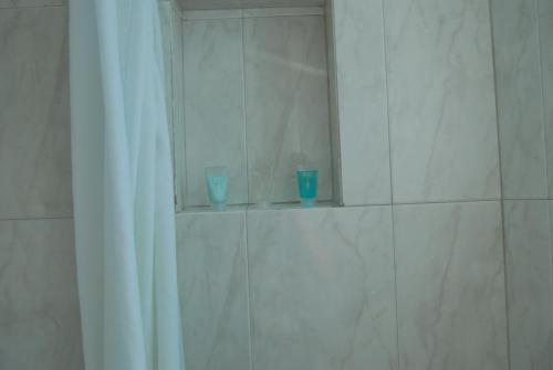 two blue glasses sitting on a shelf in a shower at Hotel Villas Las Anclas in Cozumel
