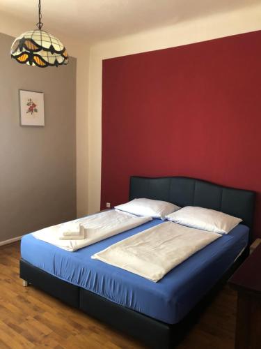 a bed in a bedroom with a red wall at Rheinischer Hof in Leverkusen