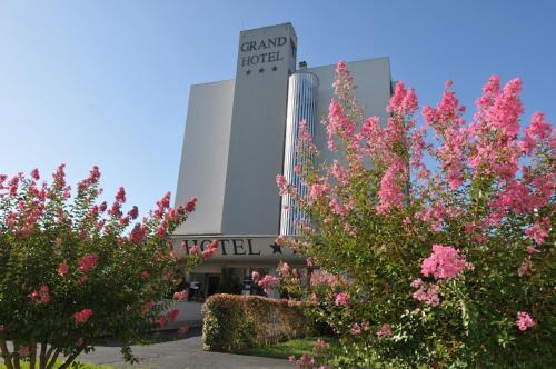 a building with pink flowers in front of it at Grand Hotel in Dax