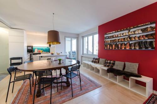 a dining room with a table and chairs and a red wall at Capsule Hotel - Lucerne TheLAB in Luzern