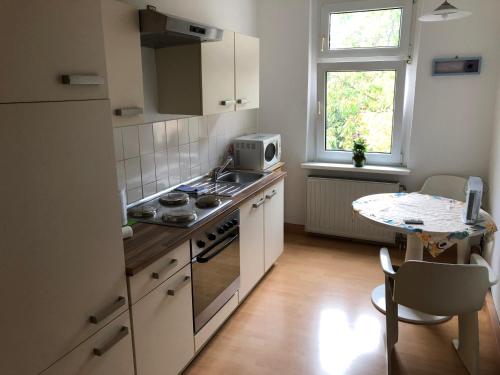 a kitchen with a stove and a table and a window at Süd-Apartments in Leipzig