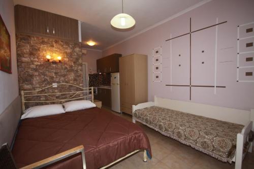 a bedroom with two beds in a room with a kitchen at ZEPHYROS ROOMS in Ormos Panagias