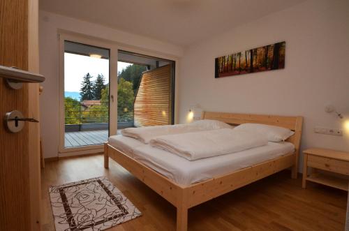 a bedroom with a bed and a large window at Aurturist Campo Tures in Campo Tures
