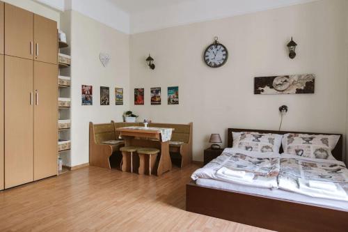 a bedroom with a bed and a desk and a clock at Apartment Caffé Latte in Budapest