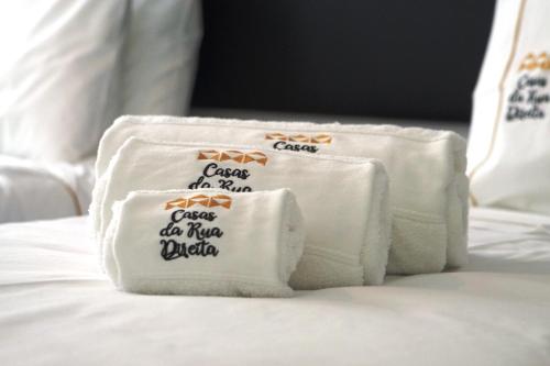 a pile of towels sitting on top of a bed at Stylish house - air cond, breakfast, free parking in Vila Nova de Gaia