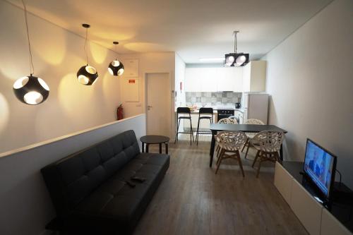 a living room and kitchen with a couch and a table at Stylish house - air cond, breakfast, free parking in Vila Nova de Gaia