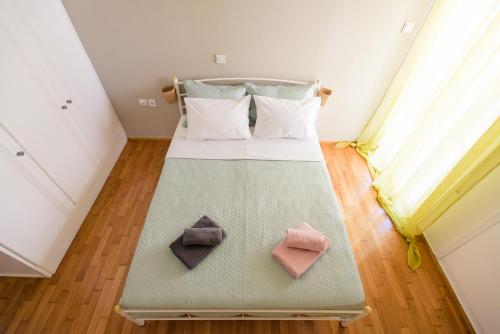 a bedroom with a bed with three pillows on it at Fotini's place! in Athens