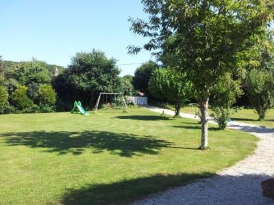 un parc avec un arbre et une balançoire dans l'établissement LD St Guénolé, à Keralcun