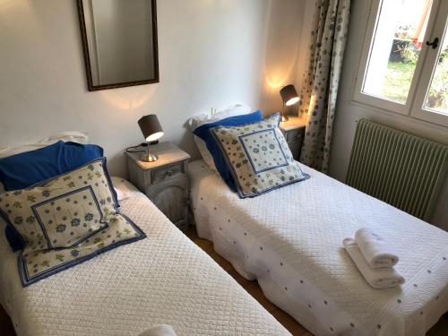 two twin beds in a room with a window at Luberon & Lavandes in Roussillon