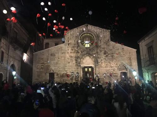 a crowd of people standing in front of a building with a clock at Dormire nel Borgo in Bovino