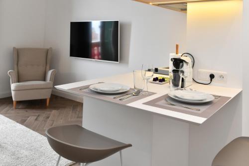 une cuisine avec un comptoir avec deux assiettes et une chaise dans l'établissement 1 bedroom Apartment next to Monaco, à Beausoleil