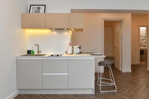 een witte keuken met een aanrecht en een kruk bij 1 bedroom Apartment next to Monaco in Beausoleil