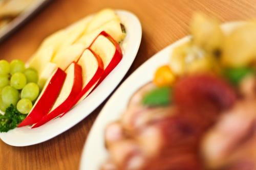 two plates of food on a table with grapes at Jungingers Aparthotel in Holzheim