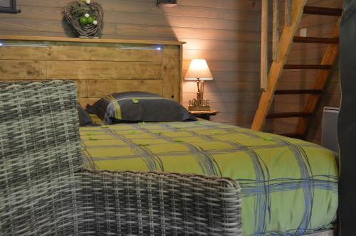 ein Schlafzimmer mit einem gelben Bett und einem Stuhl in der Unterkunft LES GITES INSOLITES DE LA CASCADE in Lespesses