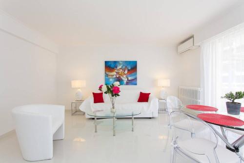 un salon blanc avec un canapé blanc et des coussins rouges dans l'établissement MARRIOTT/ CROISETTE - LUXE 1 BED, à Cannes