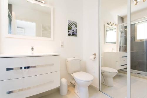une salle de bain blanche avec toilettes et douche dans l'établissement MARRIOTT/ CROISETTE - LUXE 1 BED, à Cannes