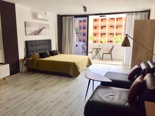 a bedroom with a bed and a living room at Suit Teror in Playa del Ingles