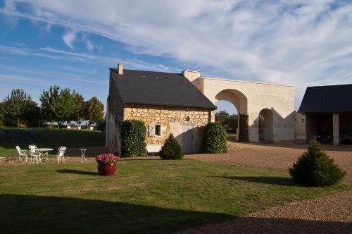 a stone building with a table and chairs in a yard at Manoir Du Bois Noblet in Louerre