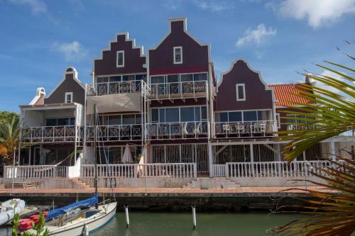 a large house on the water with a boat in front at Aqua Marina in Kralendijk