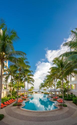 a resort swimming pool with palm trees and buildings at Jewel Grande Montego Bay Resort and Spa in Montego Bay