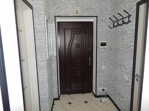 un corridoio con una porta marrone e un muro di mattoni di Ukrainska Apartment a Irpin'