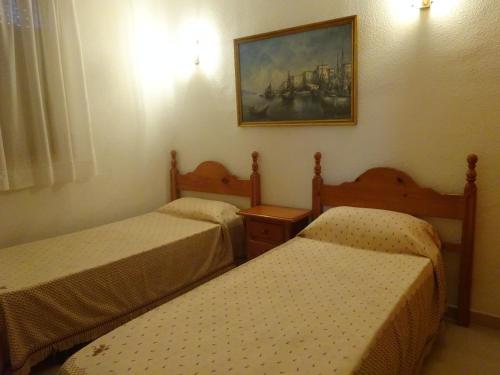 ラ・ピネーダにあるturquesaのベッド2台が備わる客室で、壁には絵画が飾られています。