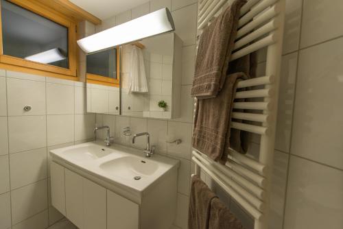 uma casa de banho com um lavatório e um espelho em Haus Belvédère em Arosa