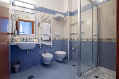 La salle de bains est pourvue de toilettes, d'un lavabo et d'une douche. dans l'établissement Angelina Residence, à Maiori