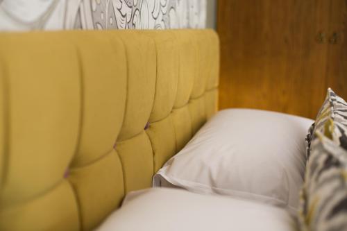 a yellow headboard of a bed with a pillow at The Stanneylands in Wilmslow
