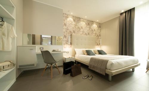 a bedroom with a bed and a desk and a chair at Hotel H21 in Milan