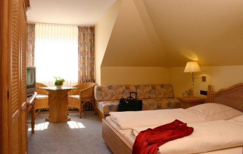 a hotel room with a bed and a couch at Landhotel Lippischer Hof in Lügde