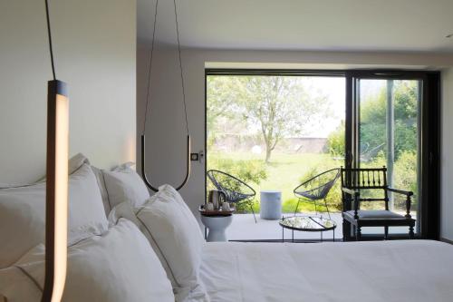 a bedroom with a bed with a view of a yard at Auberge Du Paradis in Saint-Amour-Bellevue