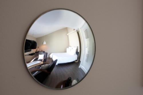 a hotel room with a bed and a mirror at Auberge Du Paradis in Saint-Amour-Bellevue