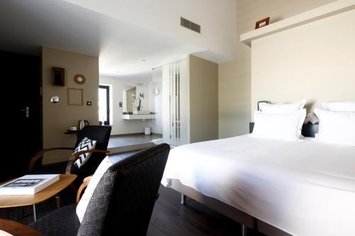 a bedroom with a large bed and a table and chairs at Auberge Du Paradis in Saint-Amour-Bellevue