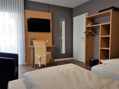 a bedroom with a bed and a television at Hotel & Restaurant Hüllen in Barweiler