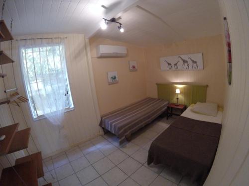 a small room with a bed and a window at La plage de Petit-Havre in Le Gosier