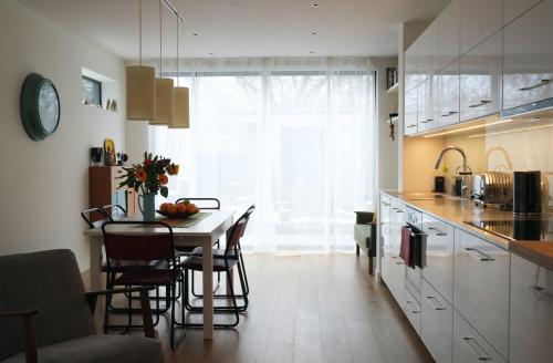 a kitchen with a table and chairs in a kitchen at Bright and Elegant 2 Bedroom Flat, near Notting Hill in London