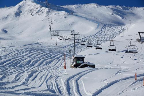 a snow covered ski slope with a ski lift at Apartamentos Grifovacances Consuegra 1 in Pas de la Casa