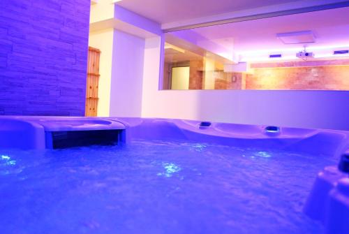 een badkamer met een bad en een grote spiegel bij Hotel Delfin in Zadar
